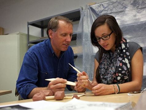 student working with teacher on project in ceramics classroom