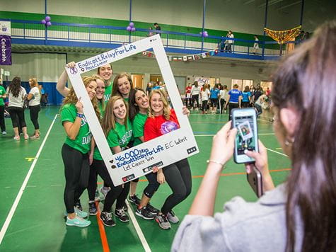 group of girls getting picture taken with a prop at an event/fundraiser