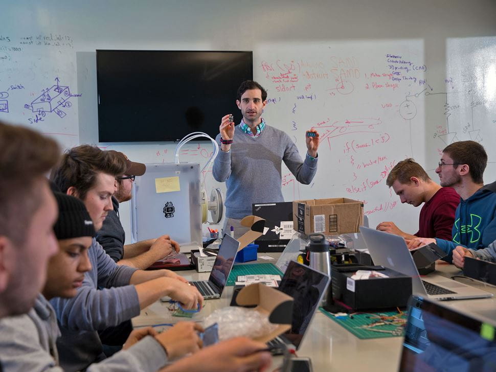 Faculty instructing students in front of an interacting whiteboard