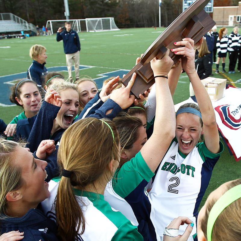 team holding up championship trophy in excitement 