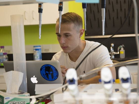 student studying on laptop in laboratory