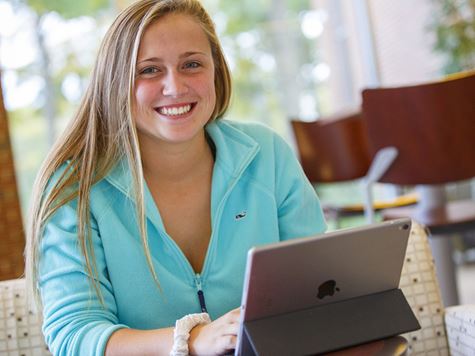 student working on laptop in lounge area