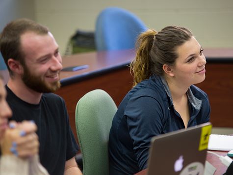 a guy and a girl attending a class and smiling