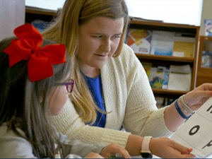 Student educating a child in a classroom