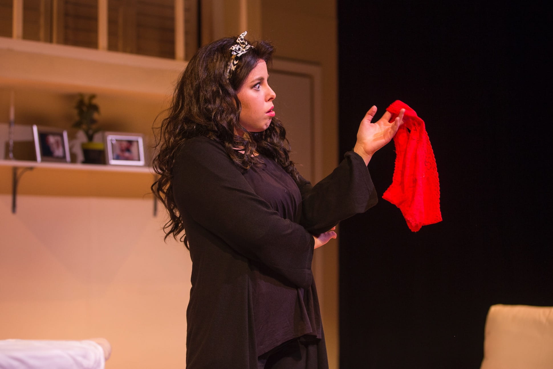 Actor holding up red cloth prop during play