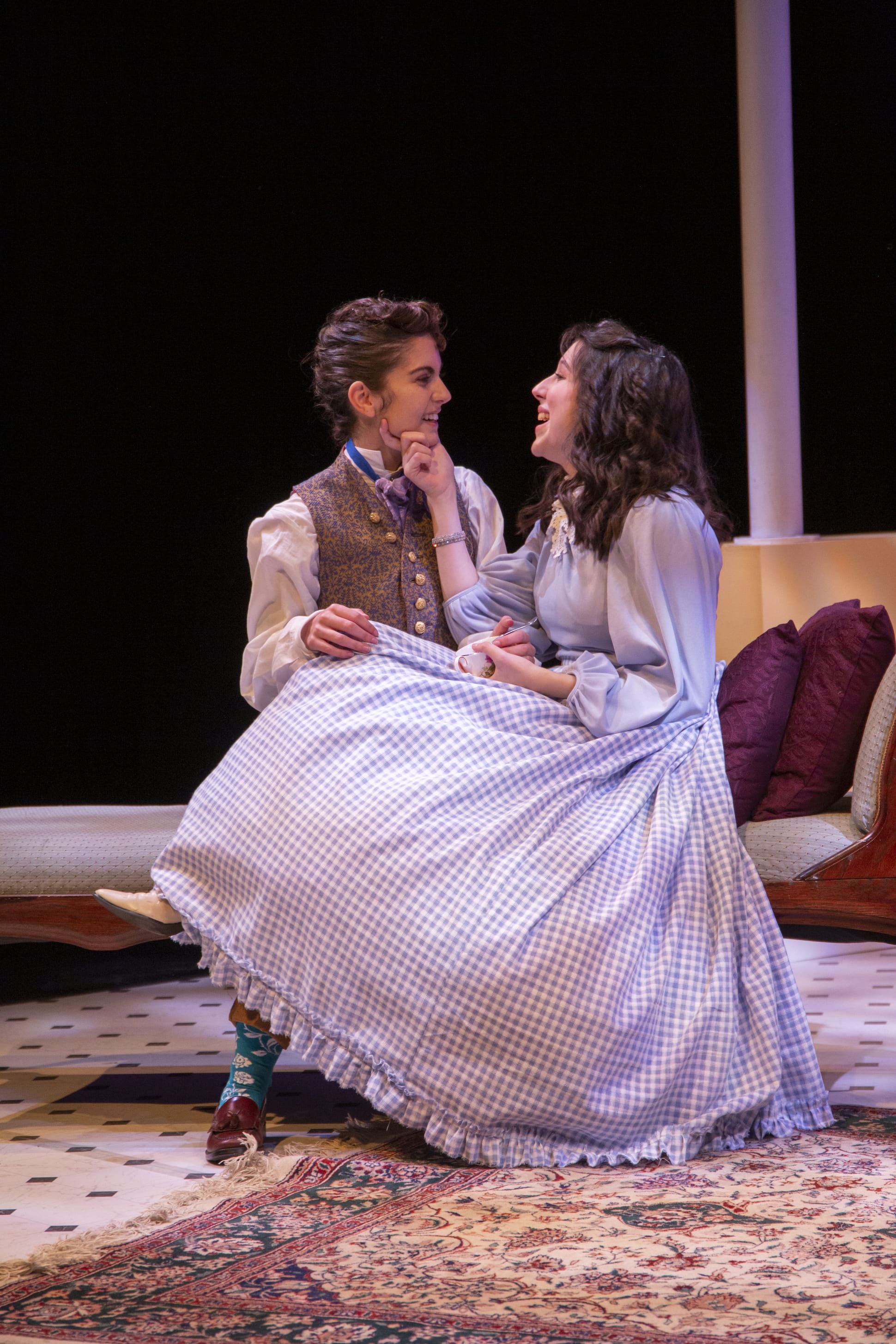 two actors sitting on same chair together
