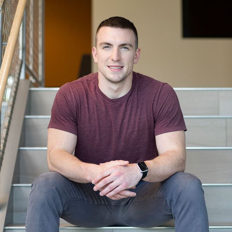 Cory Gaskell sitting down on the steps of the Samuel C. Wax Academic Center