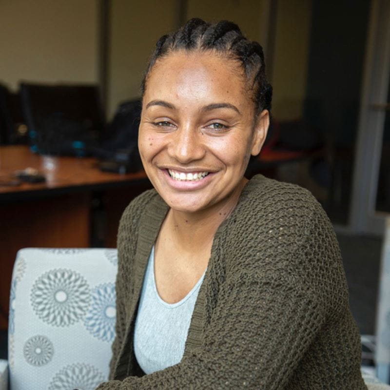 Noime Alves '19 seated in a conference room