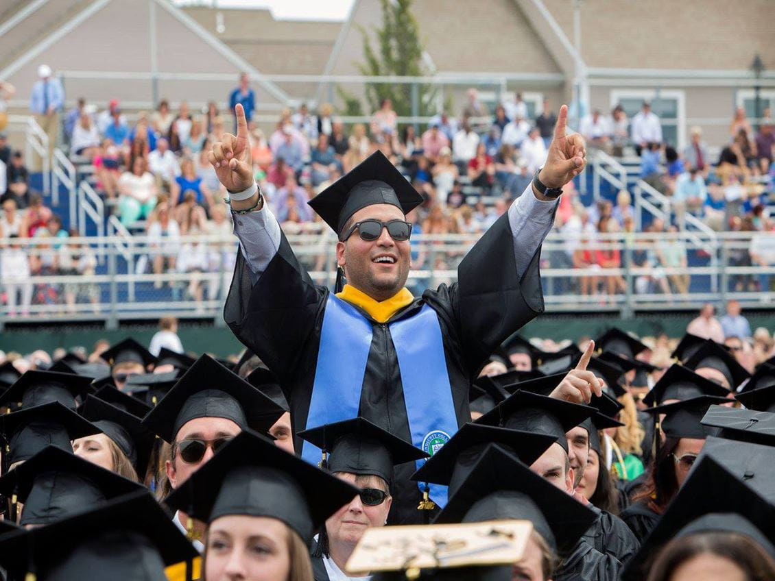 four students looking at a computer monitor