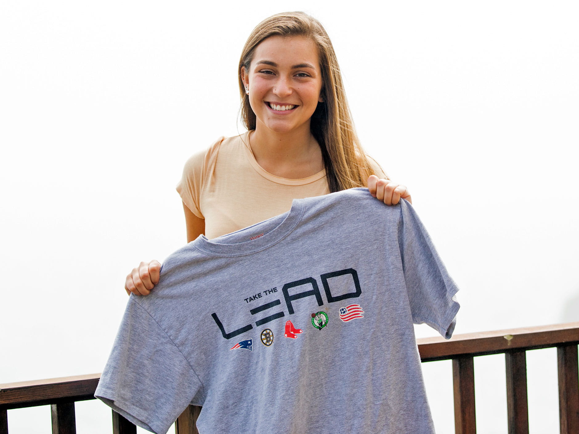 Ella Folsom-Fraster holding a "Take the Lead" tee shirt