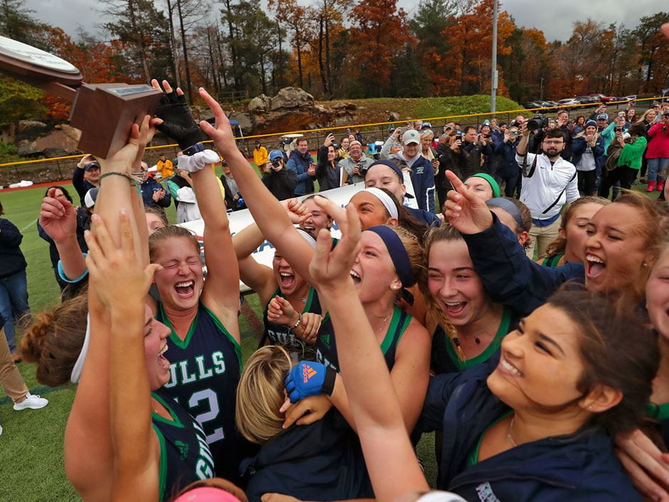 Field hockey team hoisting the CCC Championship trophy