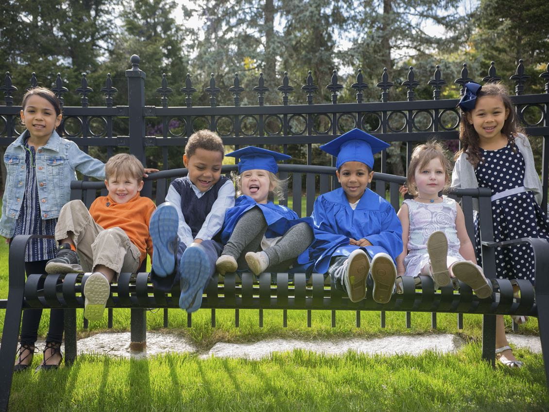 Young children sit on a bench 