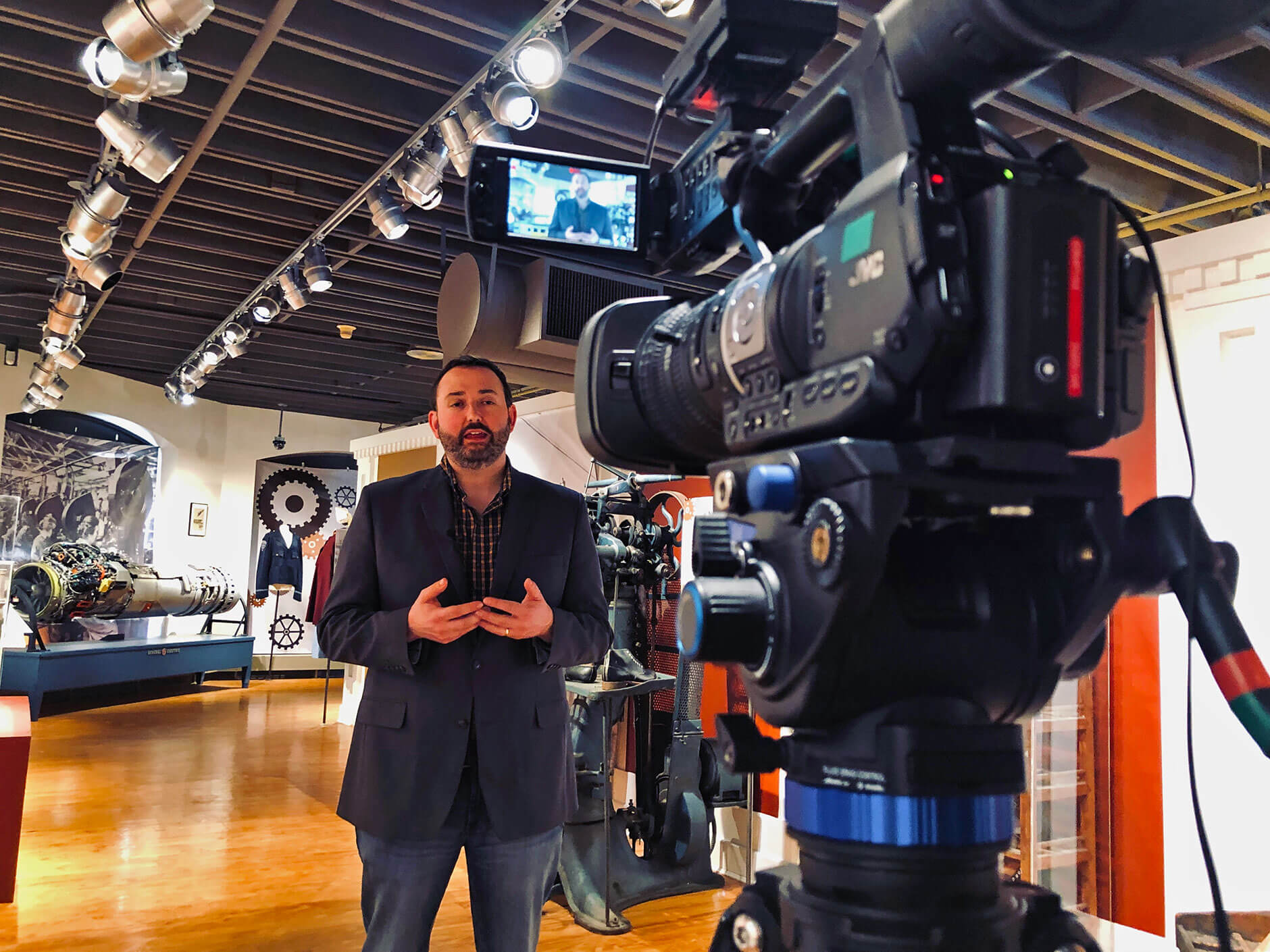Male student in front of a camera reporting