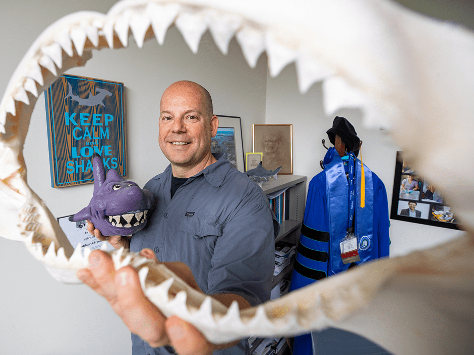 Professor Bram Lutton looking through a mold of a sharks mouth 