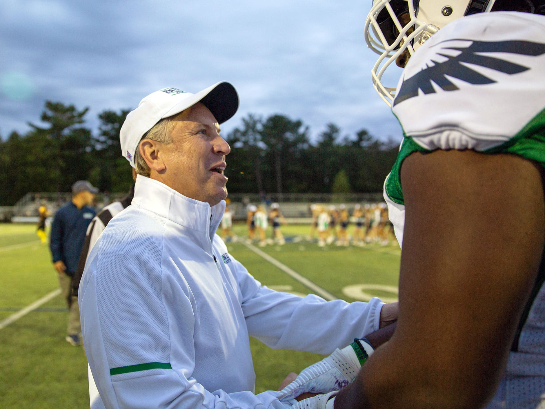 Dr. DiSalvo shaking hands with an Endicott football player 