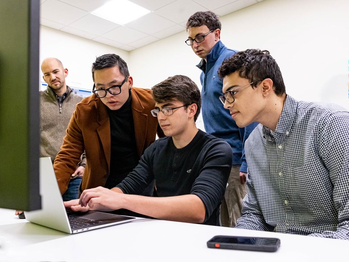 Developers of the Alive Application sit at desk and laptop for their work