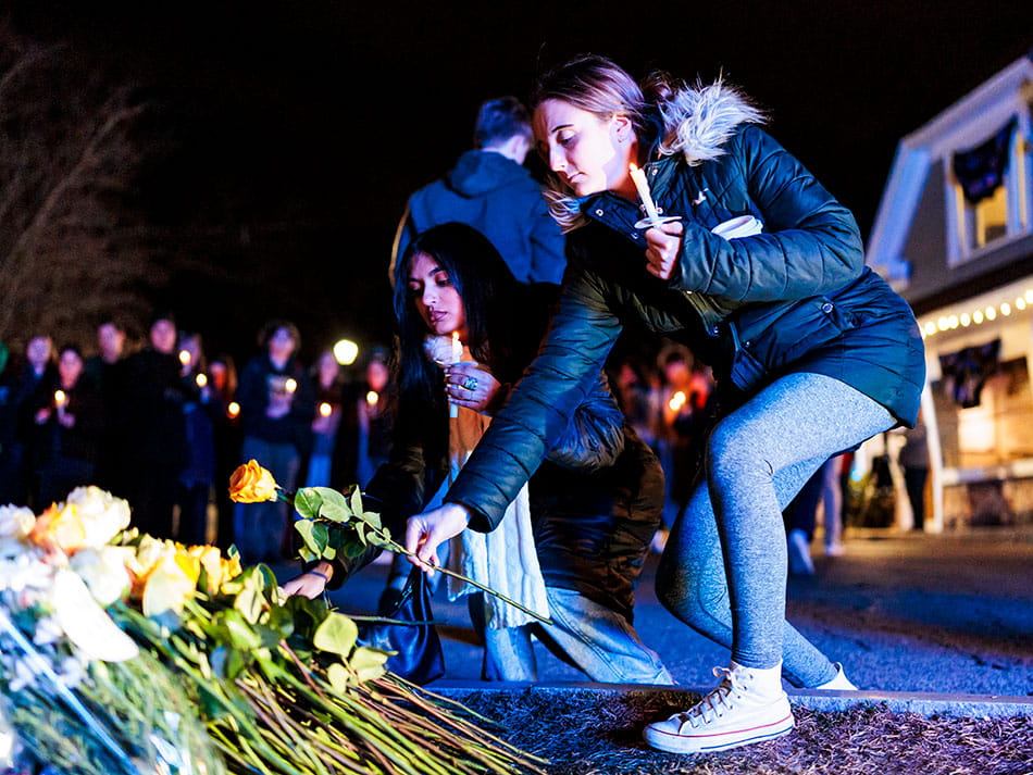 Student placing a rose on Sergeant Jeremy Cole's memorial