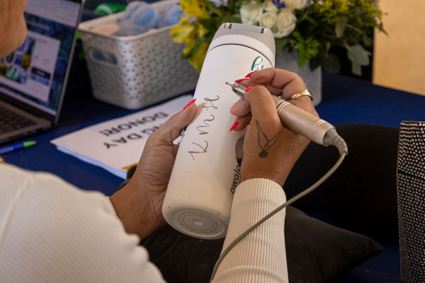 A person engraving a water bottle