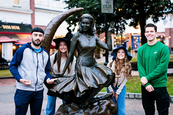 Students posing by the Bewitched statue in Salem, MA
