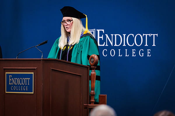 Professor Jennifer Flewelling, School of Education, at a podium during Inauguration & Convocation at Endicott College