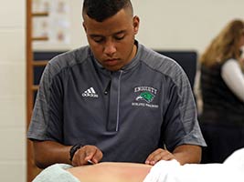 An athletic trainer works on an athlete