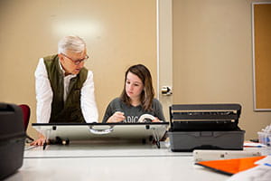 Faculty and student working together in an architectural drawing course