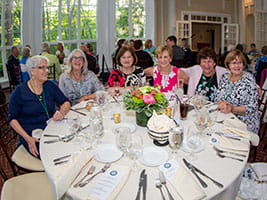 Alumni gathered around a table at Tupper Manor