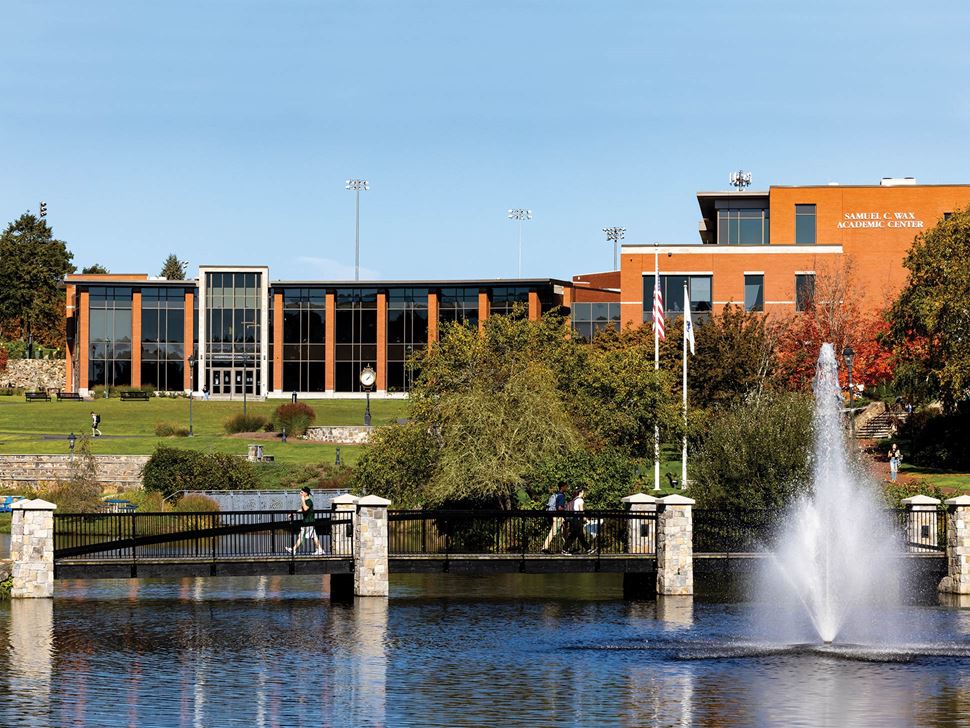 view of main enter of endicott college fountians and pond and bridge