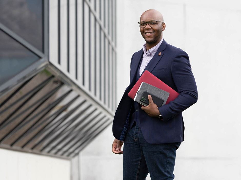 man on stairs with books in suit