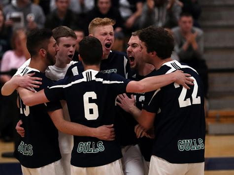 men's varisty volleyball team hugging/celebrating victory 