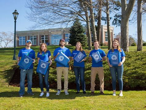 group of students holding recycling bins to promote conservation efforts