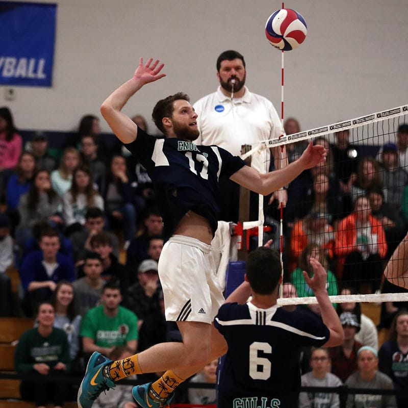 volleyball playing jumping up to spike ball over net