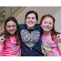 three kids smiling for a photo