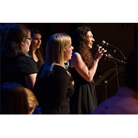 a woman singer in front of a group