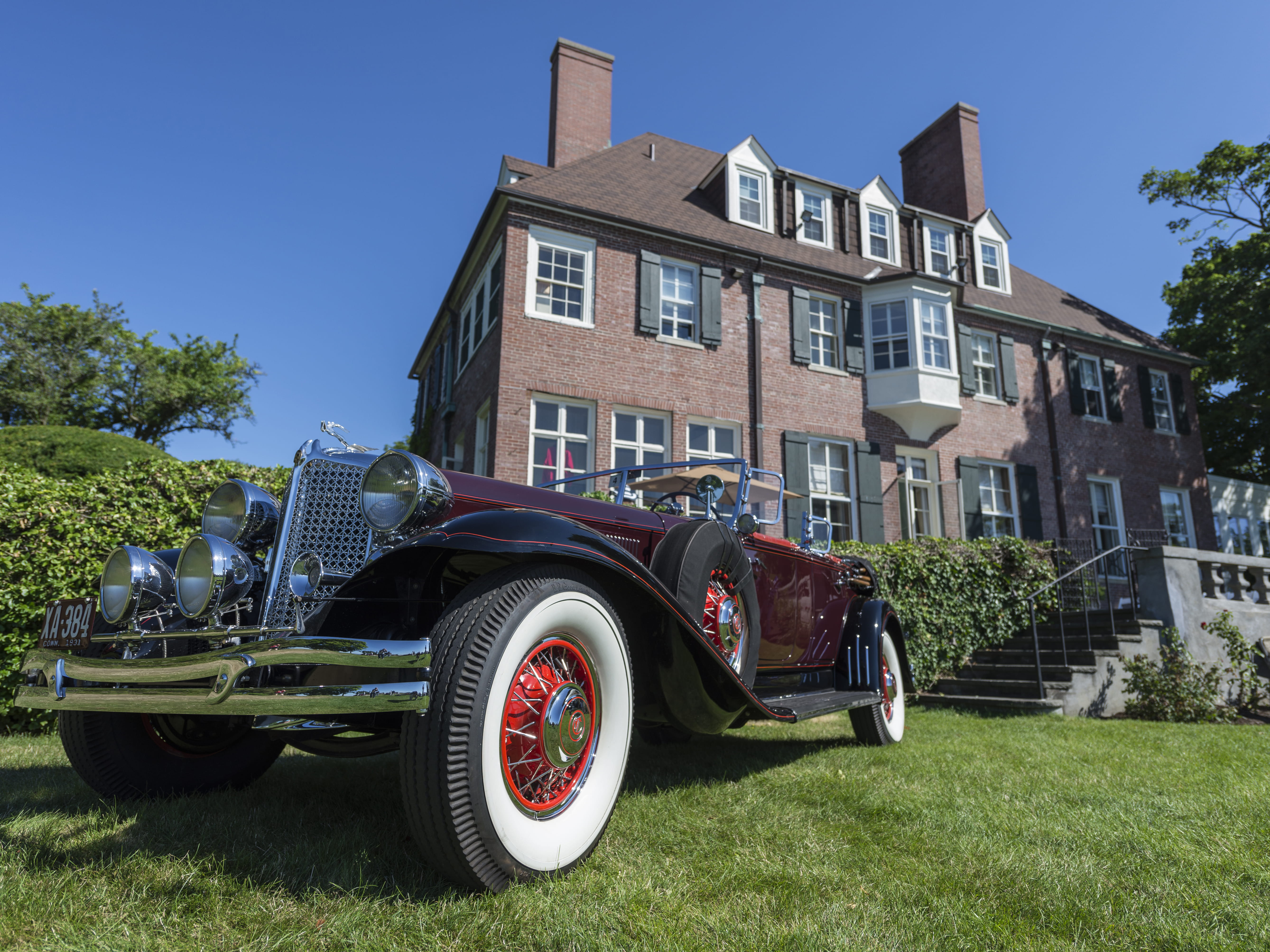a classic car parked in front of a house