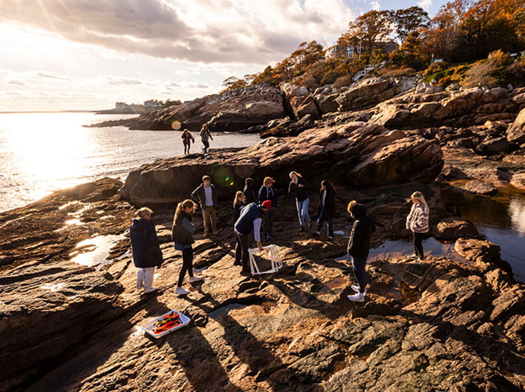 Endicott Students on rocks by the beach