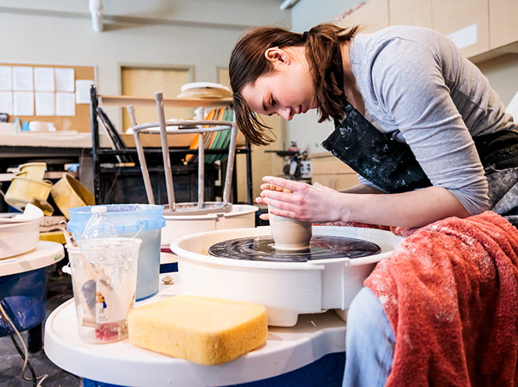 Student wheel throwing pottery