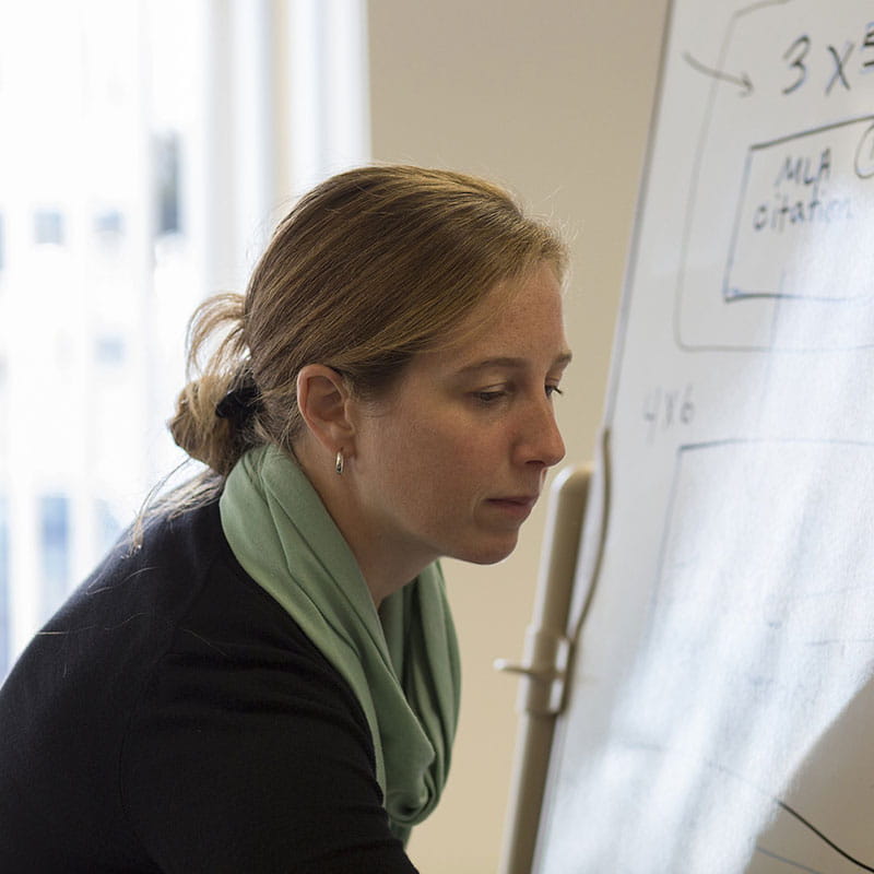 an instructor writing on poster paper