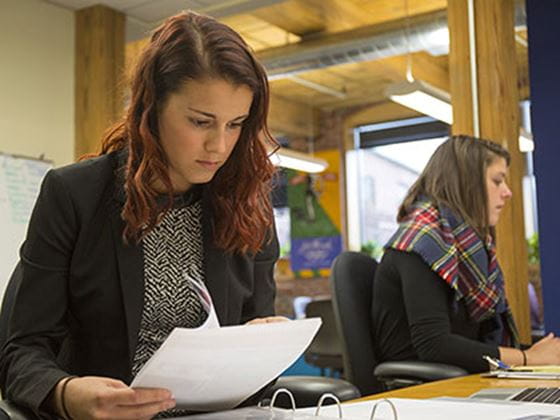 a girl flipping through papers and reading