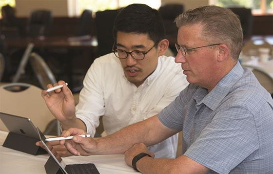 Two people working on laptops