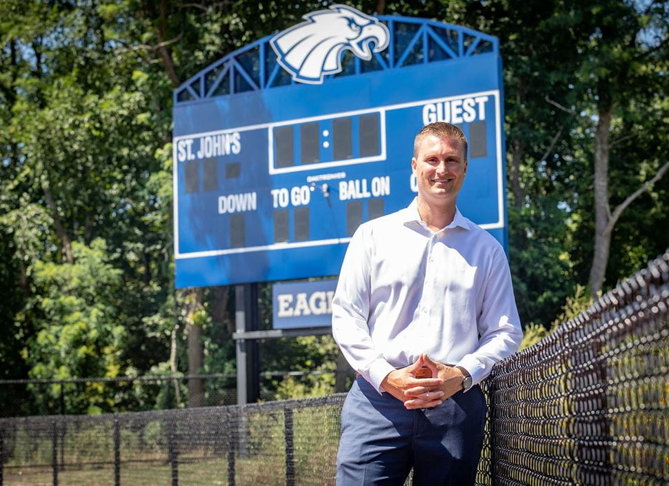 Jameson Pelkey standing in front of the St. John's Prep scoreboard